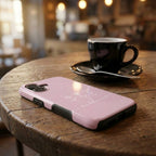 Handyhülle mit Motiv BE BLESSED in rosa liegt auf rustikalem Holztisch neben Kaffeetasse – Lifestyle