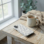 Handyhülle Glaube FOREVER LOVED in Schieferblau auf rustikalem Holztisch mit Kaffeetasse und Decke – Lifestyle