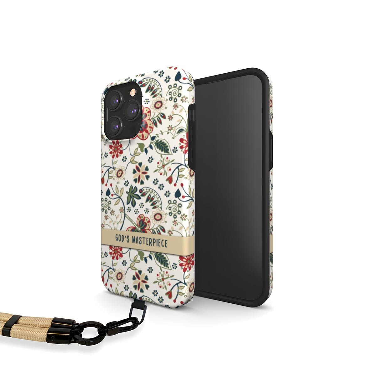 Handyhülle mit Blumenmuster und Schriftzug God's Masterpiece, unten eine beige Handyschlaufe eingehakt